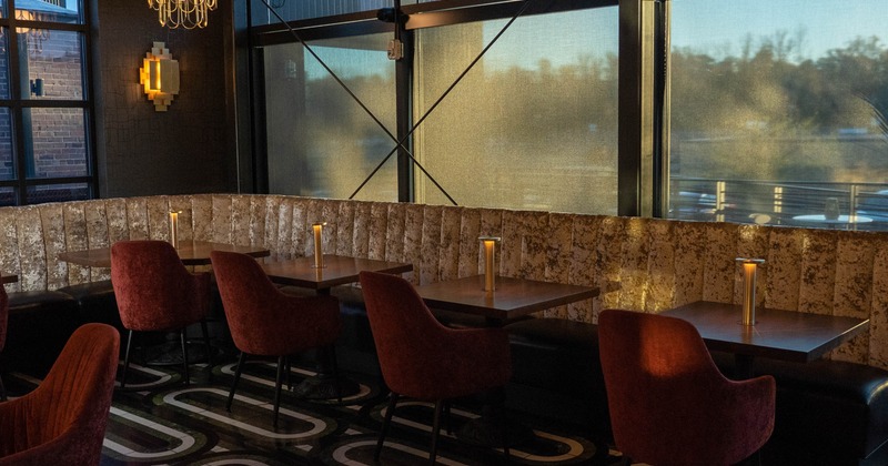 Interior, seating area, long corner banquette bench with wooden top tables and chairs