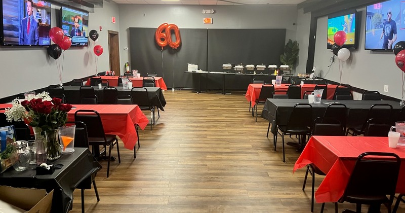 Event room with red and black decor for a 60th birthday