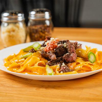 Pappardelle pasta with steak, peppers, and roasted pepper sauce.