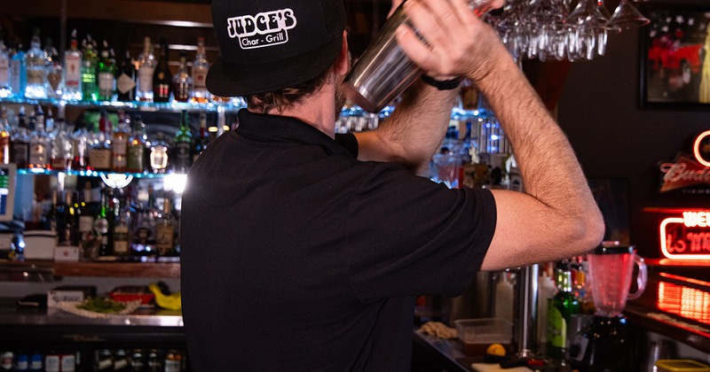 A bartender shaking cocktail ingredients