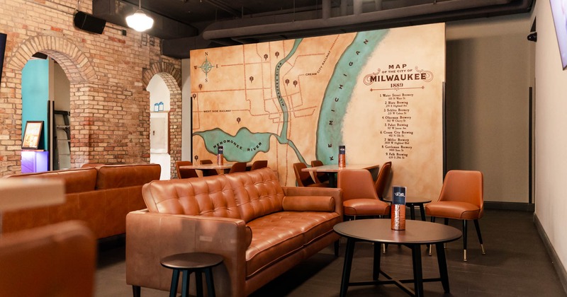 Interior, leather lounge couch with a coffee table and chairs, tables for four, a mural map