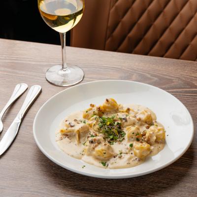 Pear and cheese stuffed pasta purses in creamy walnut sauce.