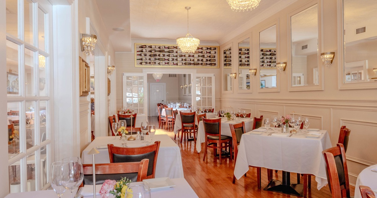 Elegant restaurant interior with wooden floors, light beige walls, crystal chandeliers