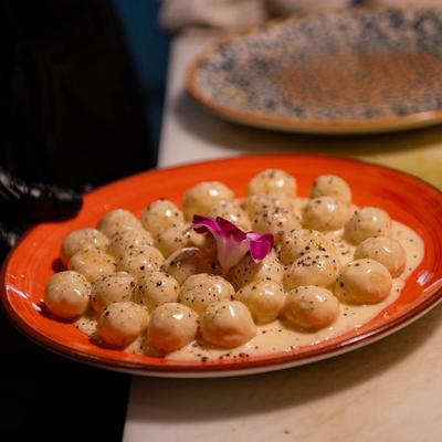 Gnocchi filled with Asiago cheese, garnished with a flower.