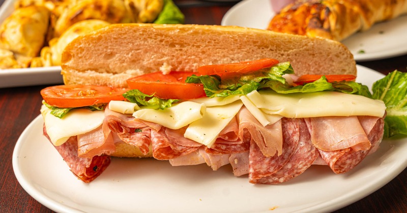 Sandwich with cold cuts, cheese, lettuce, and tomato