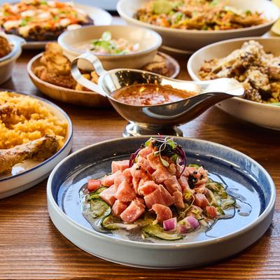 A variety of dishes are arranged on a wooden table.