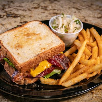 Fried Bologna Sandwich with sides of coleslaw and French fries.