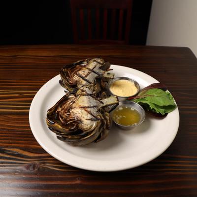Grilled Artichoke cut in half with butter and chipotle mayo.