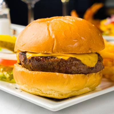 Classic cheeseburger served on plate with sides, close-up.