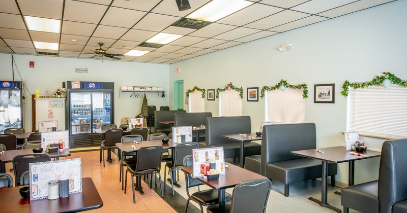 Interior, dining area, tables for four, seating booths with tables, double door fridge in the back
