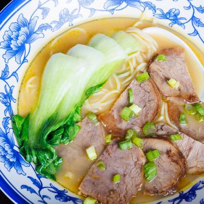 Beef noodle soup with bok choy and scallions.