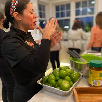 Chef stands before a bowl of green peppers, ready to prepare a dish.