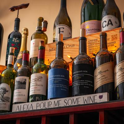 Assorted wine bottles displayed on a wooden shelf.