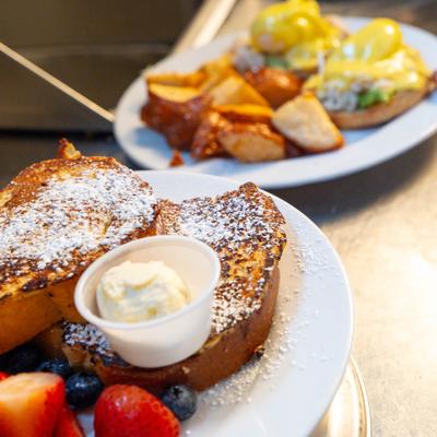 French toast with Eggs Benedict in the background.