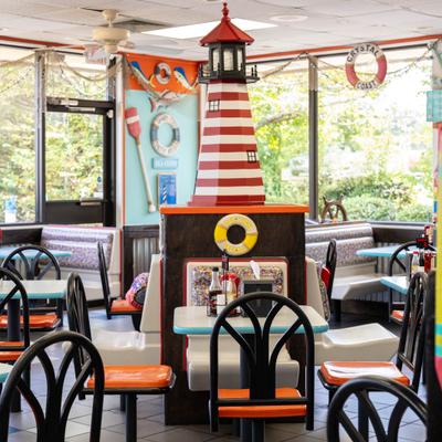 Restaurant interior featuring a prominent red-and-white striped lighthouse structure.