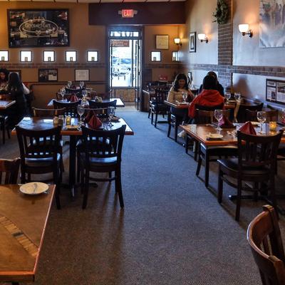Dining room with wood-paneled walls, brick accents  and framed art.