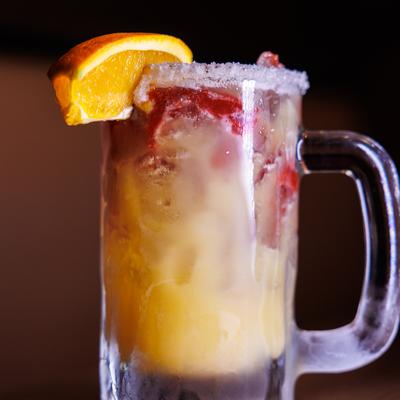 Iced cocktail with orange garnish.