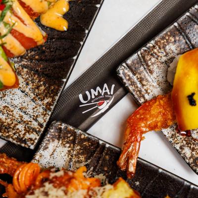 Assorted sushi plates featuring shrimp tempura and fresh avocado rolls, close view.
