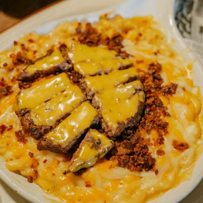 Cheeseburger Mac and Cheese topped with crumbled bacon and a cheeseburger patty.