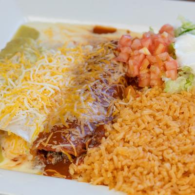 Enchiladas with melted cheese, rice, diced tomatoes, lettuce, and sour cream.