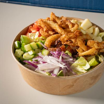 Chopped salad with fried chicken, cucumber, apple, red onion, and lettuce.