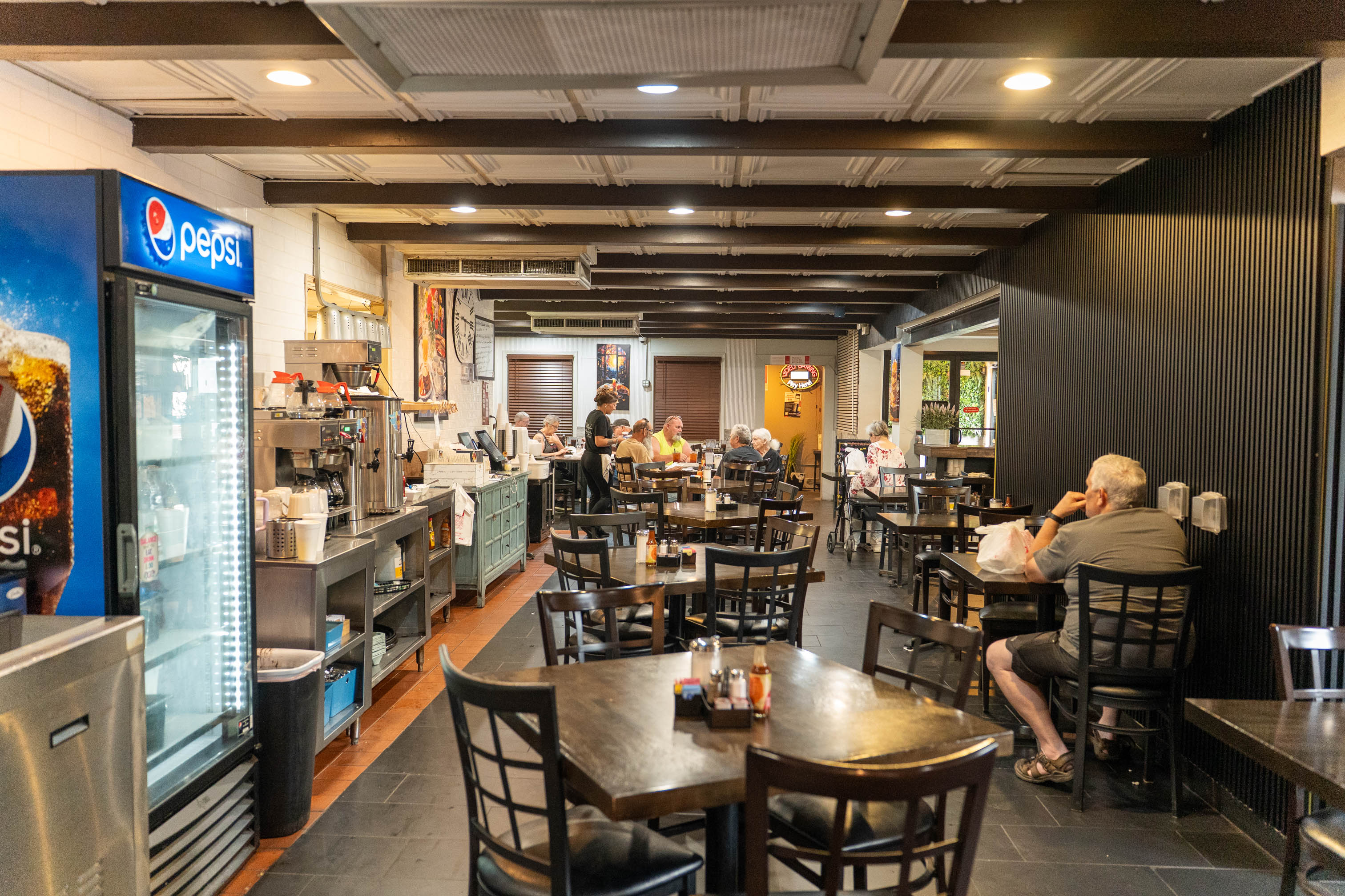 An indoor restaurant dining area filled with tables and seated customers