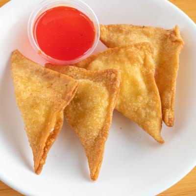 Crab Rangoon served with a side of sweet and sour dipping sauce.
