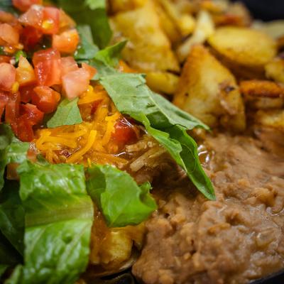 Poblano pepper, stuffed with scrambled eggs, with green chili, cheddar, tomato, and potatoes.