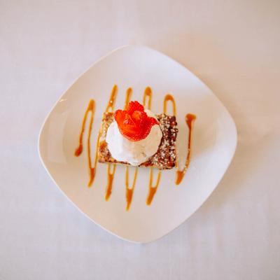 Bread pudding toped with whipped cream and strawberry.