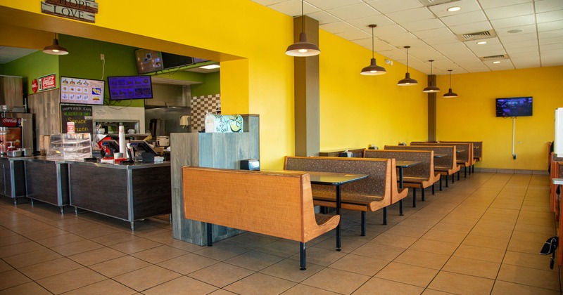 Interior, seating area, checkout counter on the left, tile flooring, TV on the wall