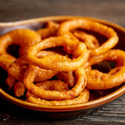 Crispy onion rings in a shallow bowl.
