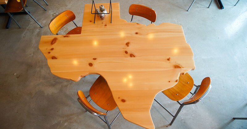 Interior, detail, a wooden table in shape of Texas, top view