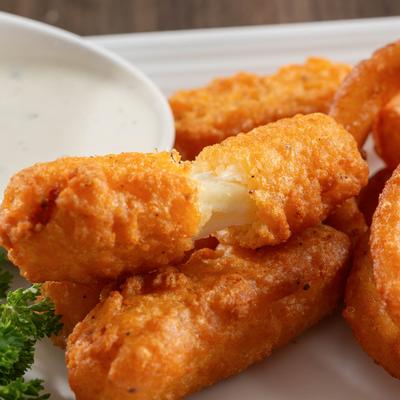 Mozzarella sticks with ranch sauce on the side.