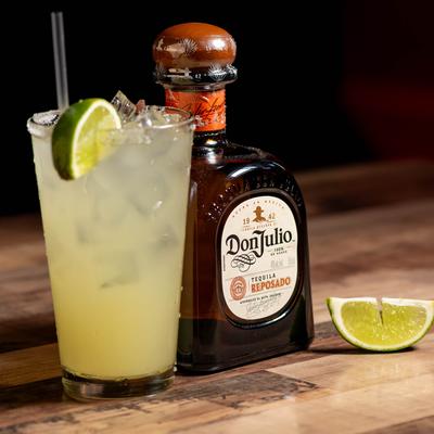 Margarita cocktail served with bottle of tequila.