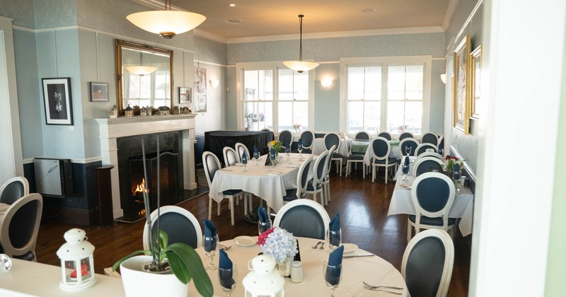 Interior, dining area, white cloth tables ready for guests, hardwood flooring