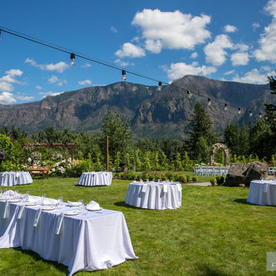 One larger table and four small ones in restaurant grass area
