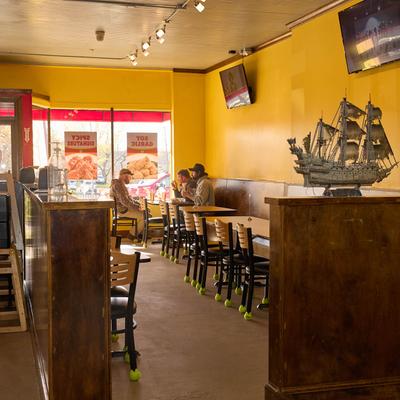 Interior with tables, chairs, guests dining, and a sailing boat model.