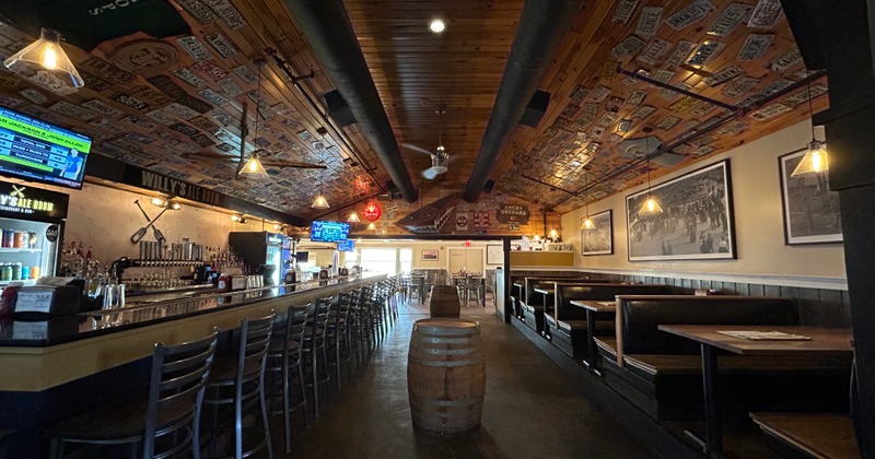 Interior featuring a long bar counter, booths, and framed photos on a wall