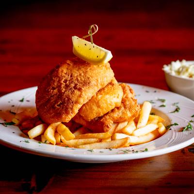 Fish and Chips served on a white plate, with a side of coleslaw.