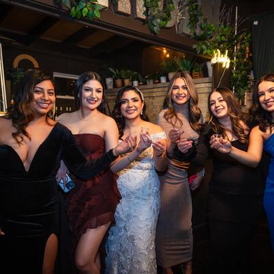 Interior, a bride and bridesmaids posing for a picture with drink shots in their hands