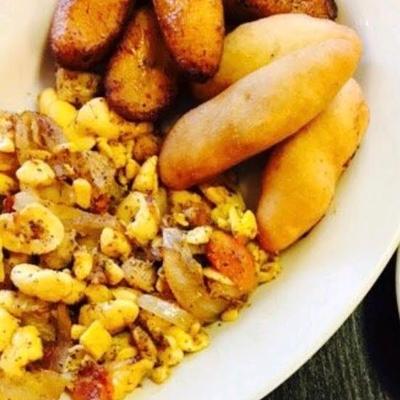 Ackee and Saltfish, with herbs, onions, tomatoes, and fried plantains.