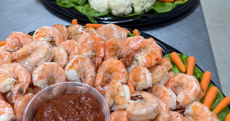 Shrimp platter with cocktail sauce and baby carrots