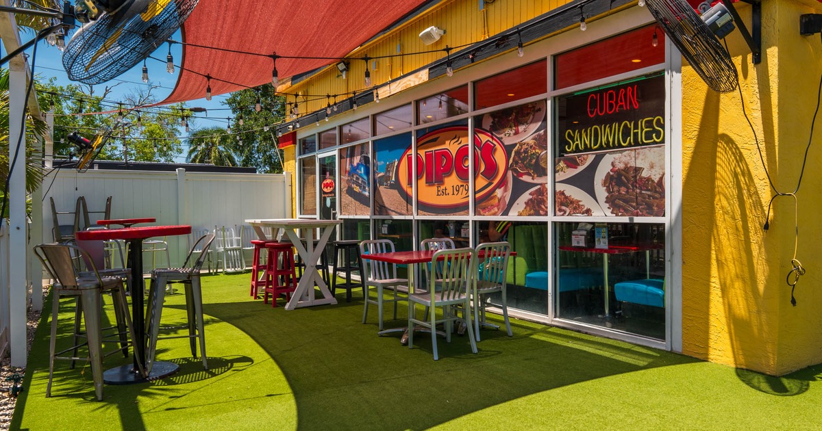 Exterior, partially covered seating area restaurant front, high and regular seating tables