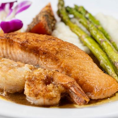 Salmon and shrimp served with asparagus and mashed potatoes.