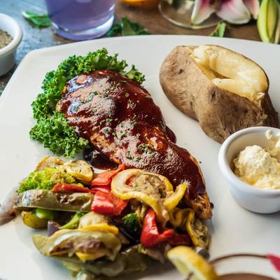 Bourbon Glazed Chicken with vegetables, a baked potato and butter