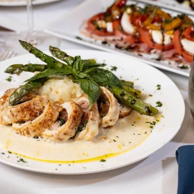 Stuffed chicken breast in creamy sauce served with asparagus and mashed potatoes.