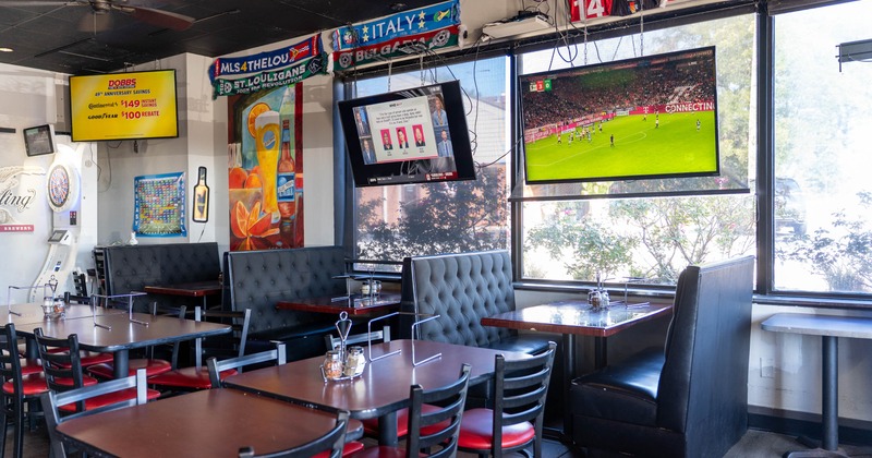 Interior of a sports bar with dining tables, booths, soccer memorabilia