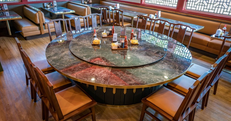 Interior dining area with round marble dining table with wooden chairs