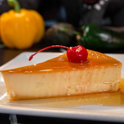 Tres leche cake topped with a cherry.