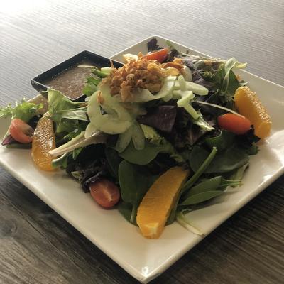 House Salad, with mixed greens, sprouts, cucumber, tomatoes, and crispy onions.